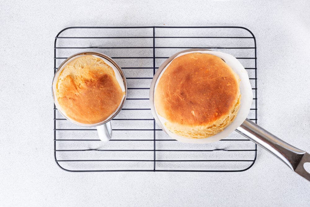 baked easter bread on a rack in a mug and pan.