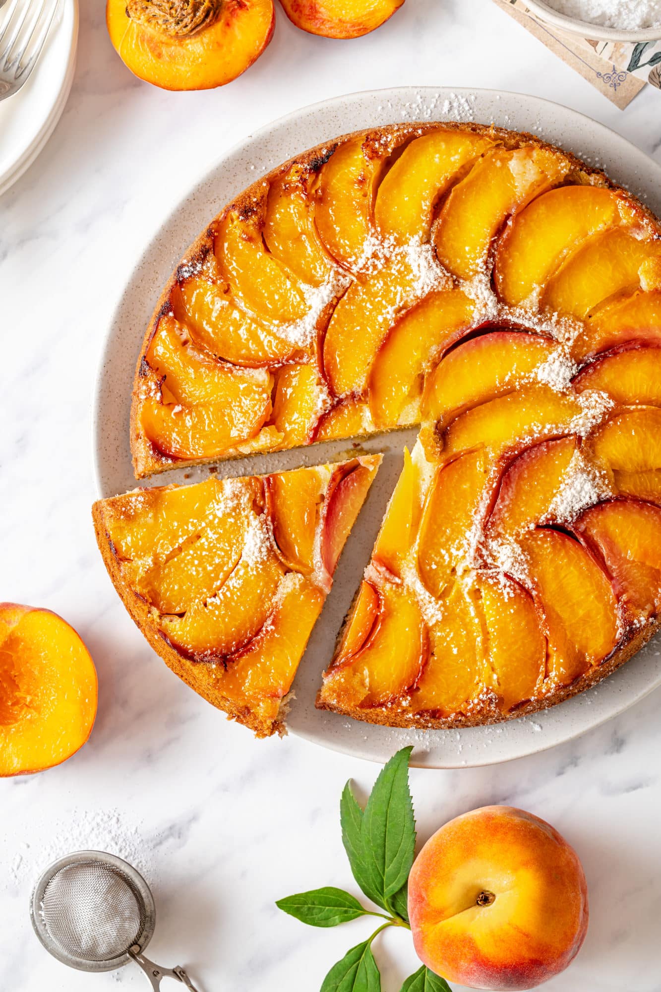 Upside Down Peach Cake in 60 Minutes Slice of peach upside down cake on a white plate with the rest of the cake.