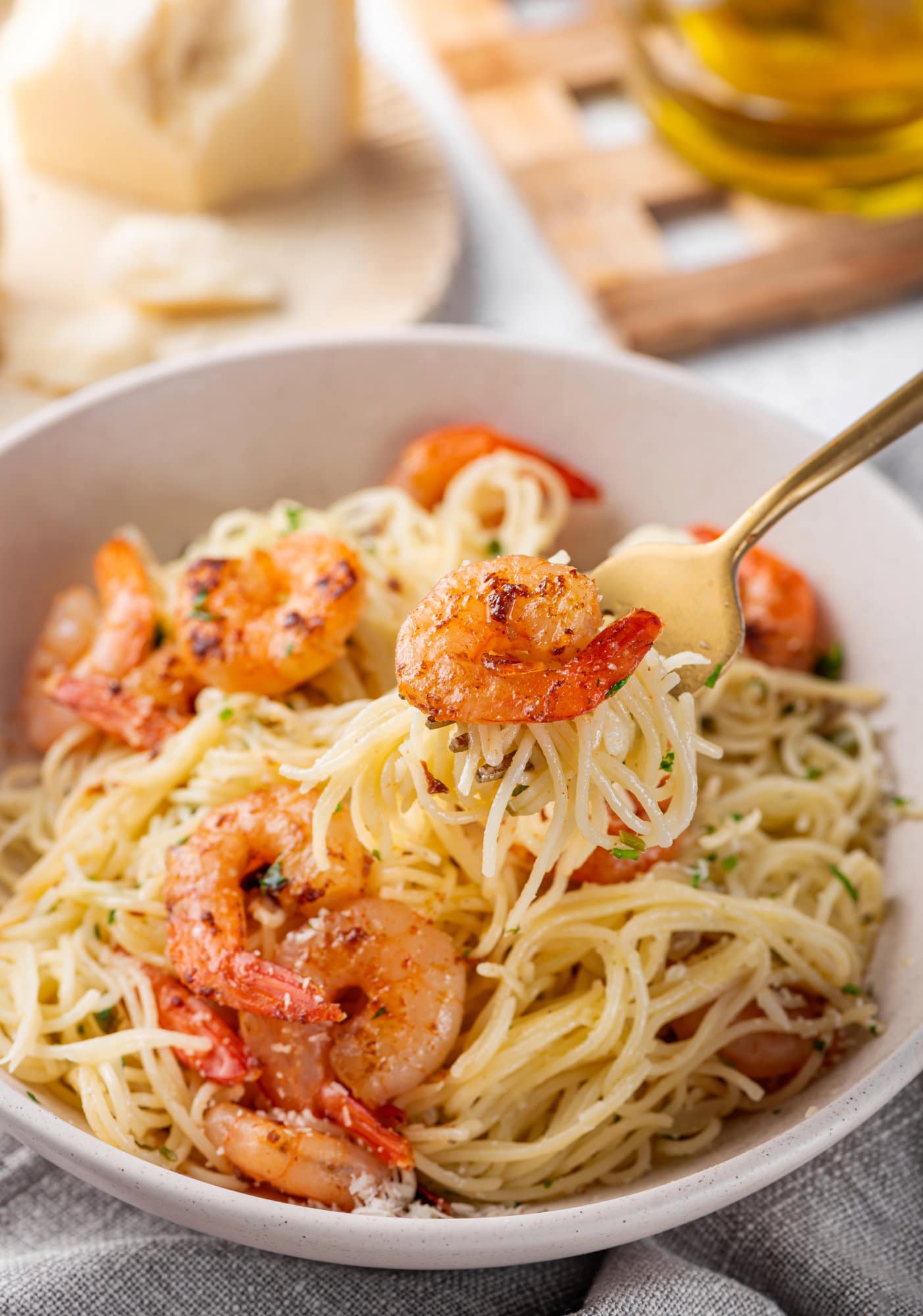 Garlic Butter Shrimp Pasta capellini-shrimp-in-a-bowl-with-a-gold-fork-on-a-grey-towel