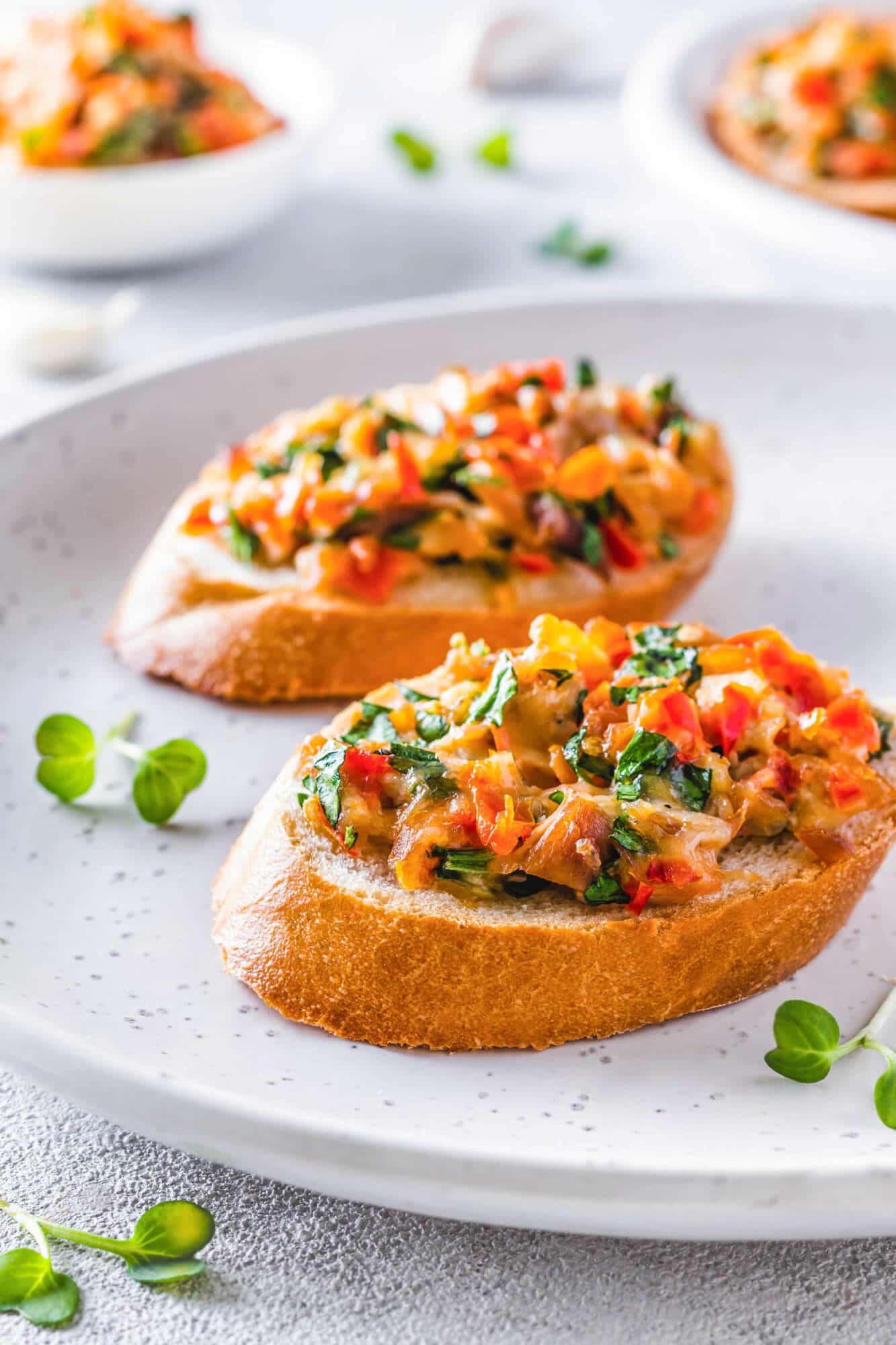 Easy Cheesy Bruschetta Chicken Bake with Tomatoes Bruschetta on a white plate with microgreens.