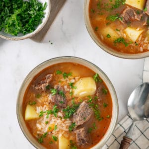 Simple Homemade Beef and Rice Soup (Kharcho) beef-soup-in-a-beige-bowl-with-a-spoon
