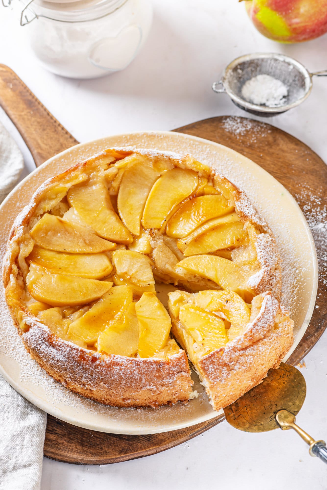 Apple Sharlotka Recipe (Russian Apple Cake) apple sharlotka recipe cake baked and put on a plate with sifted powdered sugar.