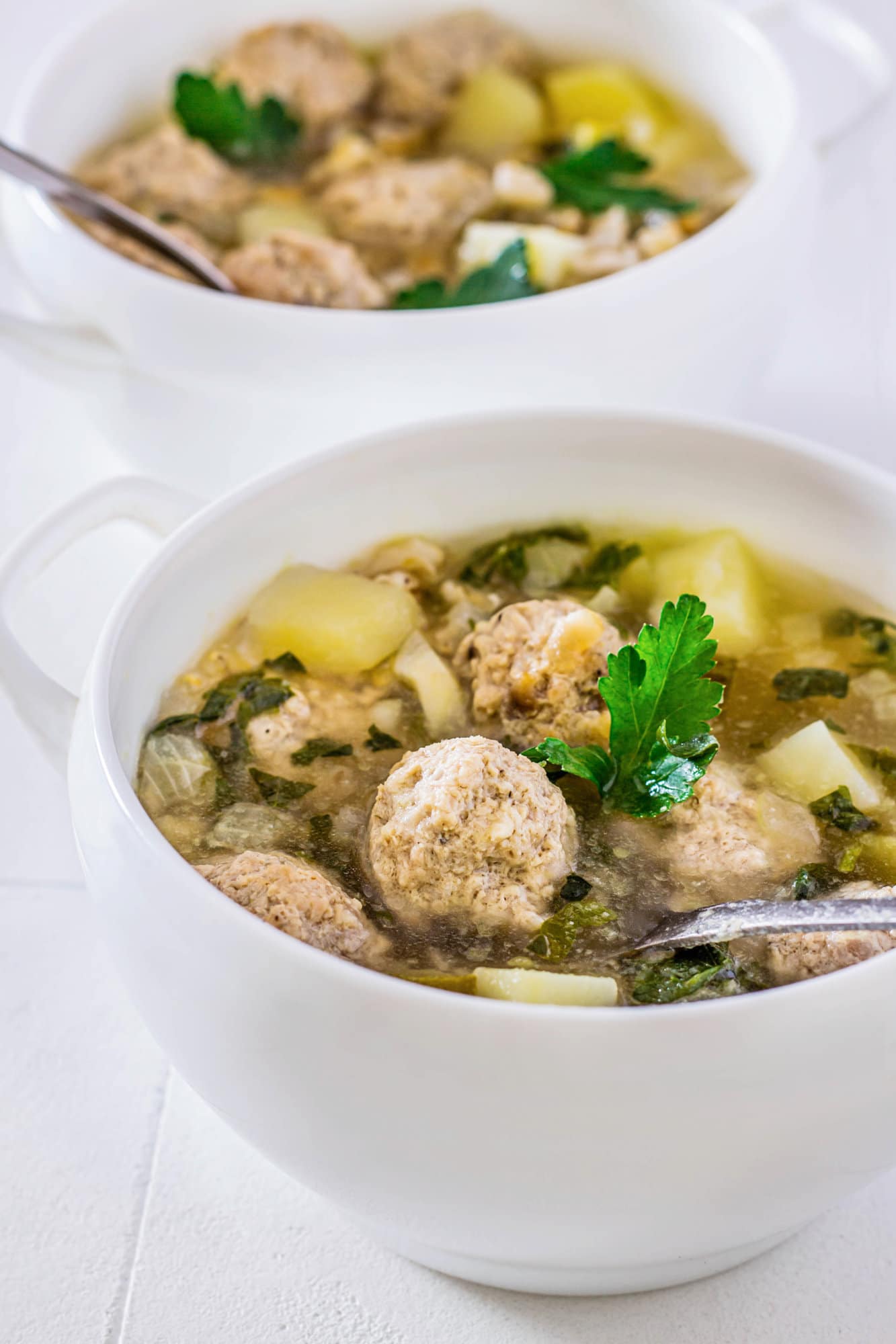 meatball-soup-in-a-white-bowl-with-a-spoon
