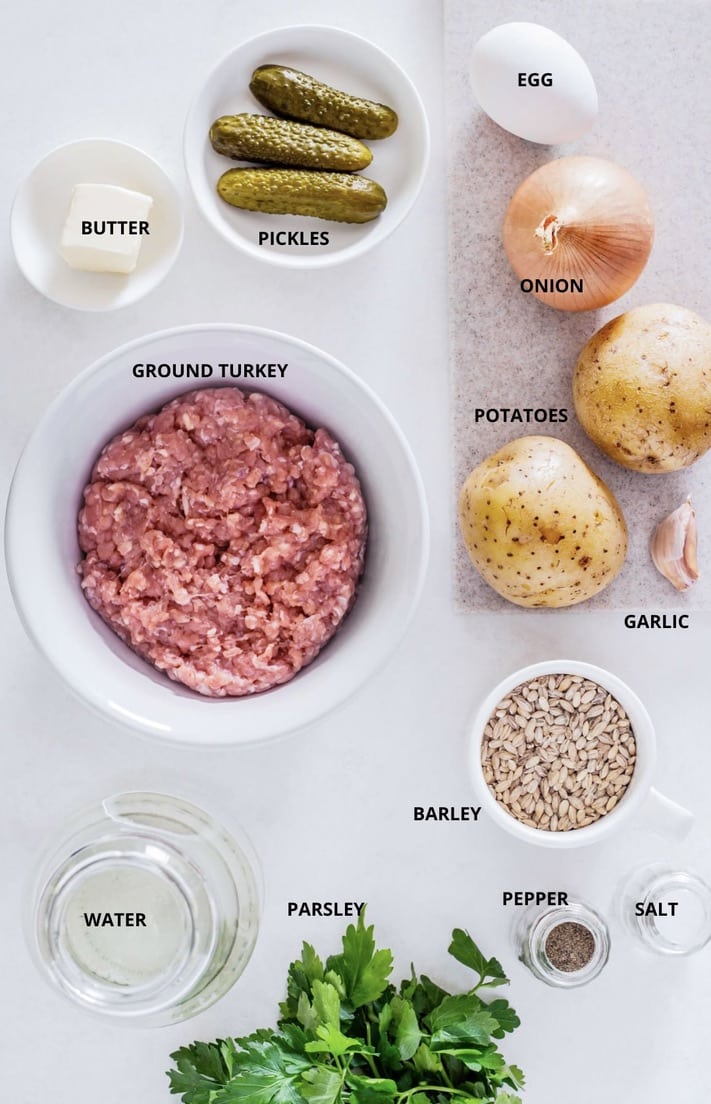 Hearty turkey soup ingredients- egg, onion, potatoes, pickles, butter, garlic, barley, pepper, salt, water, parsley, and ground turkey.