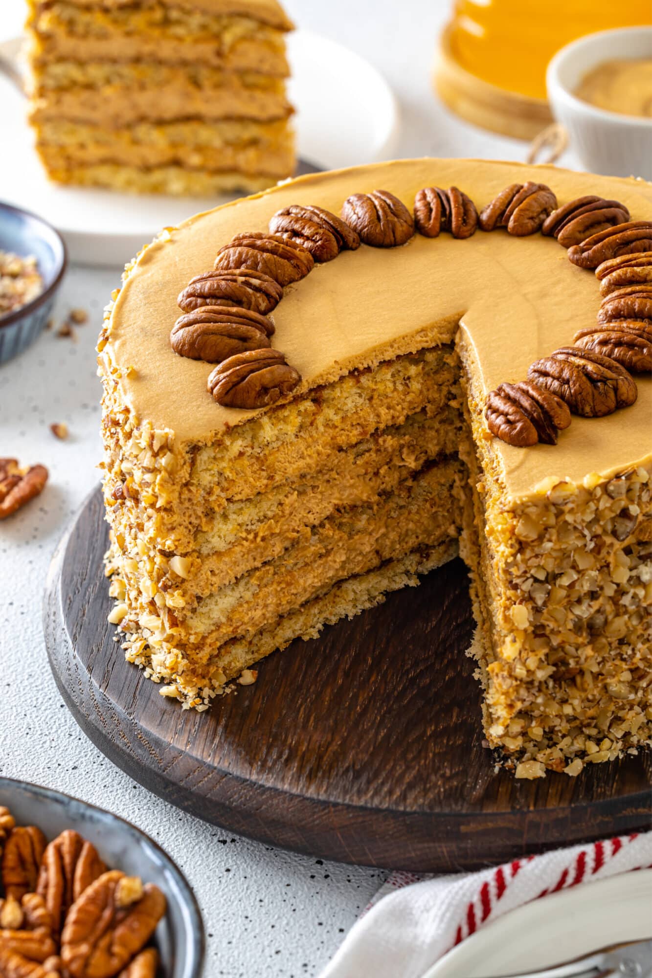 Simple Honey Cake with Cream and Dulce de Leche Honey pecan cake with pecans decorating the top.
