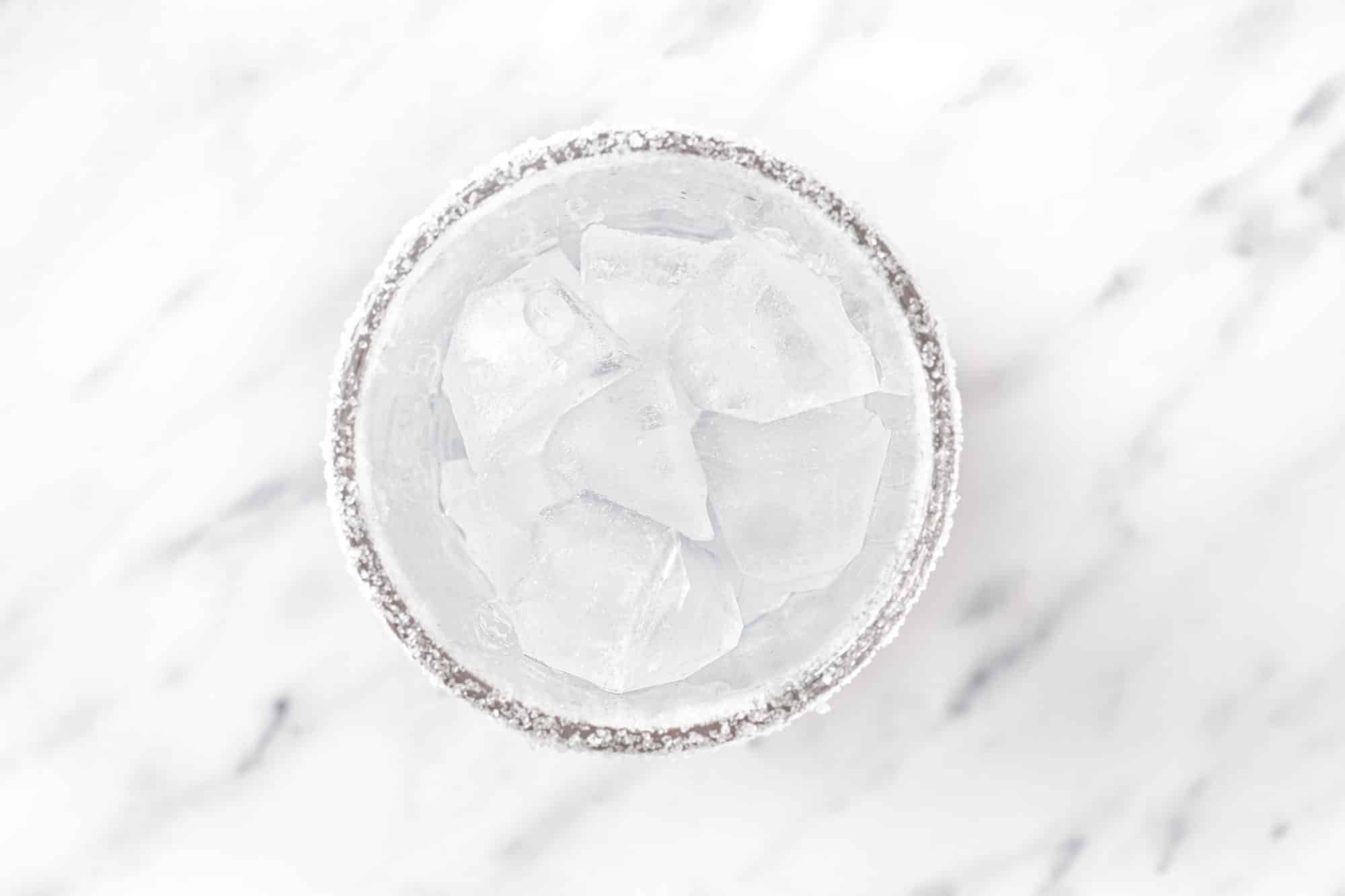 ice in a glass with sugar on the rim.