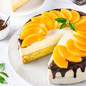 Serving a peach cake on a white plate.