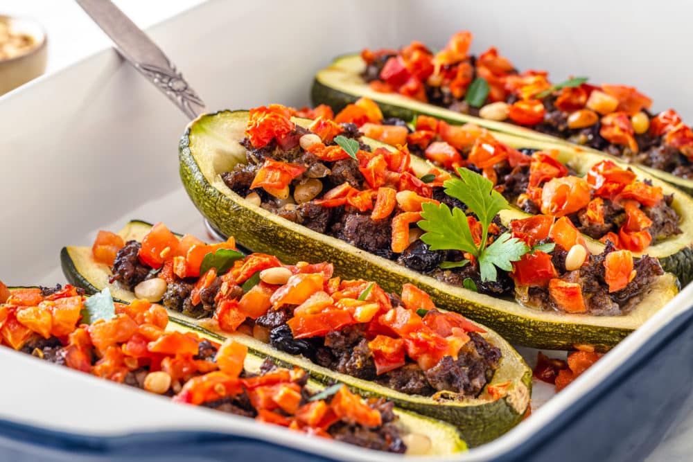 8 Low Carb Recipes That Fit Any Lifestyle! boats of stuffed zucchini laying baked in a baking dish.
